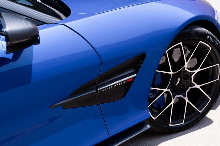 Vista lateral del Aston Martin Vanquish Volante, mostrando su elegante dise&ntilde;o y detalles estilizados.