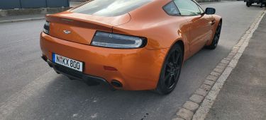 Vista trasera-lateral de un Aston Martin, destacando su diseño deportivo y elegante.