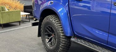 Neumático robusto con llanta de aleación en vehículo pickup azul, enfocado en su durabilidad y diseño.