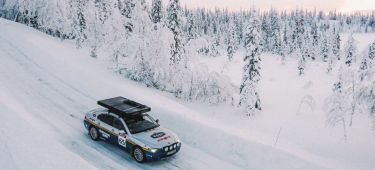 Vista lateral de un BMW Serie 7 habilitado para rally en un entorno nevado.
