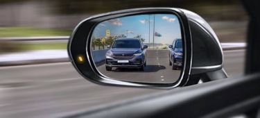Reflejo de un vehículo en movimiento captado desde el espejo retrovisor.