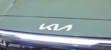 Vista frontal parcial del Kia Picanto 2024 destacando el emblema y las luces diurnas.