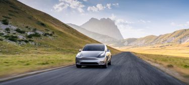 Vista dinámica del Tesla Model Y mostrando su elegante diseño y prestancia en carretera.