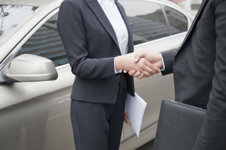 Business People Shaking Hands By Car Business People Shaking Hands By Car